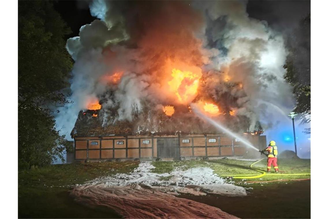 Feuer in Museumsscheune in Uetersen löst Großeinsatz aus Feuerwehrleute löschen das Feuer in der mit Reet gedeckten Museumsscheune. Foto: -/TNN/dpa