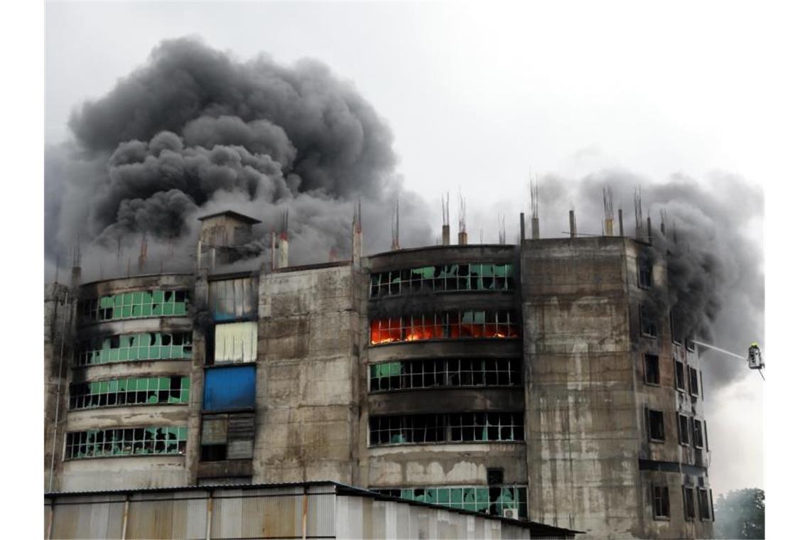 Feuerwehrleute löschen den Brand in einer Lebensmittelfabrik in Bangladesch, bei dem mindestens 52 Menschen ums Leben gekommen sind. Foto: Harun-Or-Rashid/ZUMA Wire/dpa