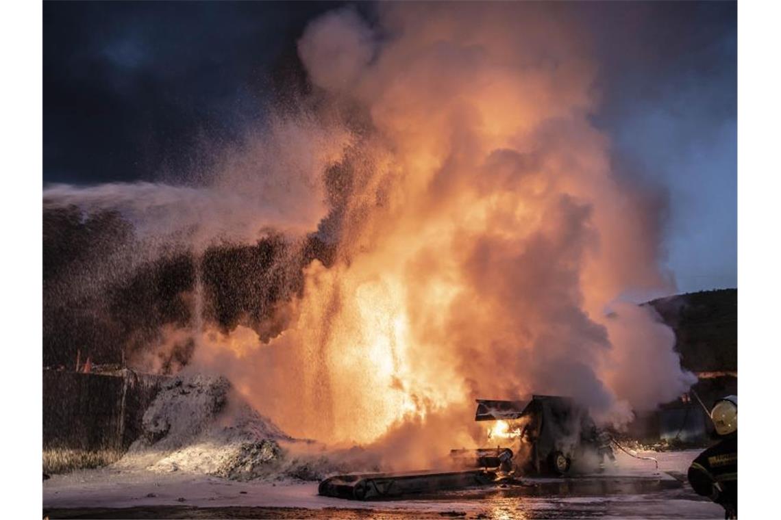 Feuerwehrleute löschen ein Feuer auf einer Mülldeponie. Ist eine entsorgte Batterie beschädigt, kann sie erhitzen und daraus können sich Brände entwickeln. Foto: Christian Schulz/Symbol