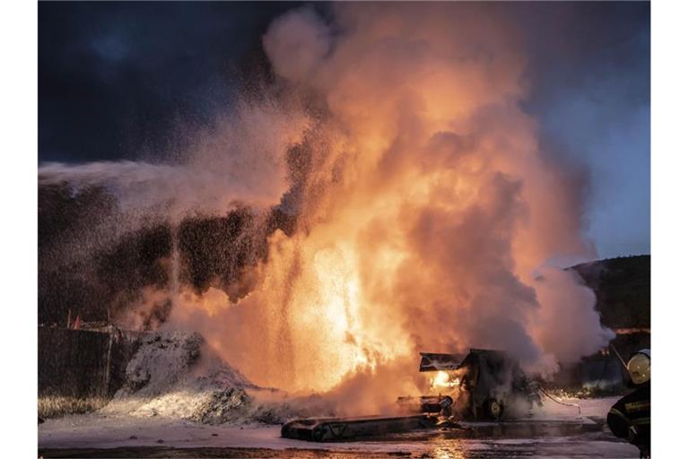 Feuerwehrleute löschen ein Feuer auf einer Mülldeponie. Ist eine entsorgte Batterie beschädigt, kann sie erhitzen und daraus können sich Brände entwickeln. Foto: Christian Schulz/Symbol