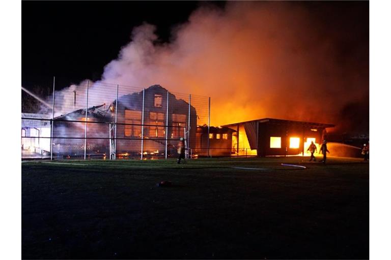 Feuerwehrleute löschen einen Brand im Sportheim. Foto: Hemmann/SDMG/dpa