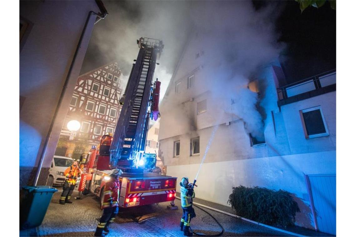Polizei: Bislang keine rassistischen Motive für Brandsätze Feuerwehrleute löschen einen Brand in einem Gebäude in der Marbacher Innenstadt. Foto: Simon Adomat/VMD-Images/dpa/Archivbild