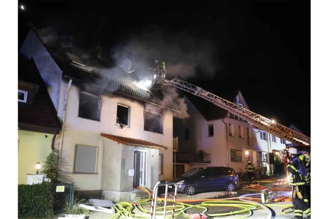 Feuerwehrleute löschen einen Brand in einem Wohnhaus. Foto: Ralf Zwiebler