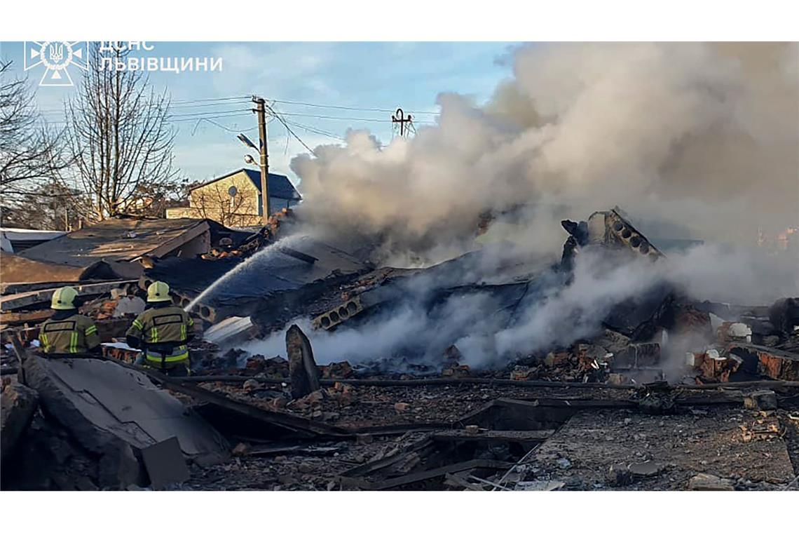 Russland greift Ukraine massiv an - Tote und Zerstörungen Feuerwehrleute löschen einen Brand in Lwiw nach einem russischen Raketenangriff.