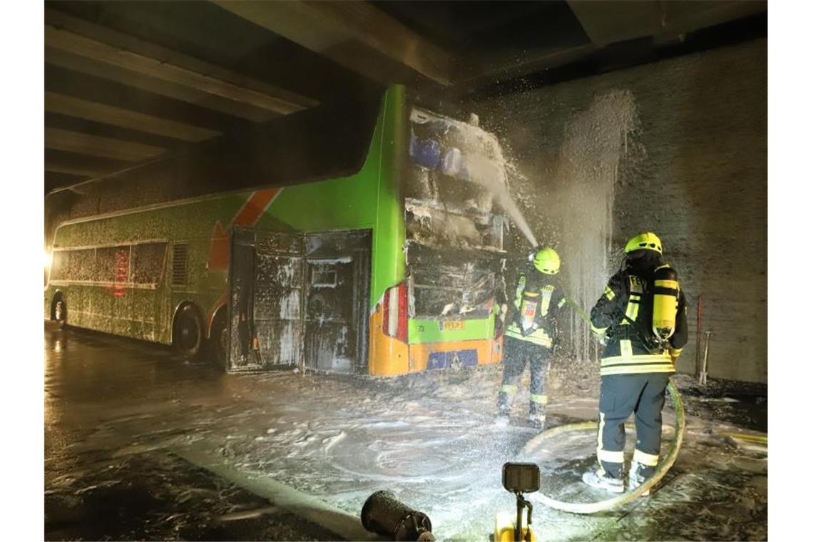 Feuerwehrleute löschen einen Reisebus. In einem Reisebus ist auf der Autobahn 1 bei Bremen ein Feuer ausgebrochen. Foto: Christian Butt