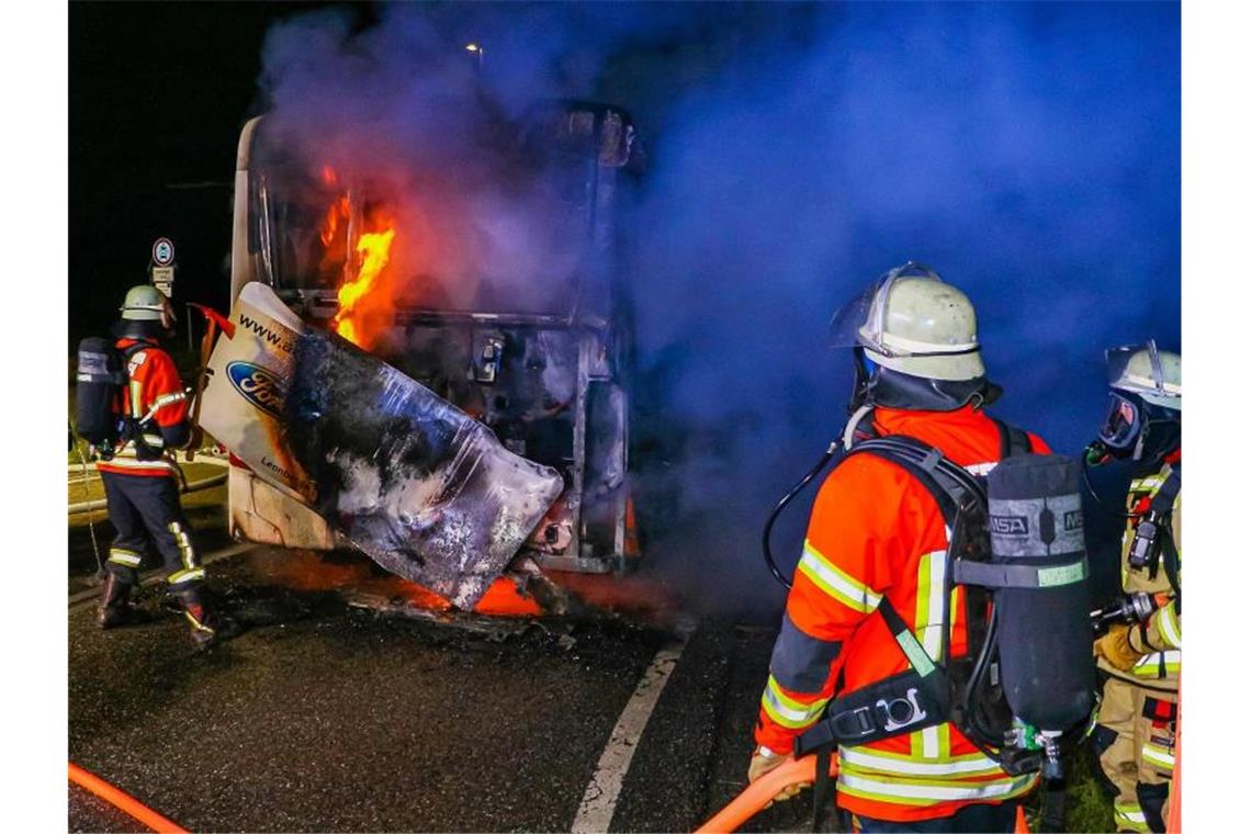 Linienbus fängt während der Fahrt Feuer Feuerwehrleute löschen in der Nacht einen Brand in einem Linienbus. Foto: Andreas Rometsch/KS-Images.de/dpa