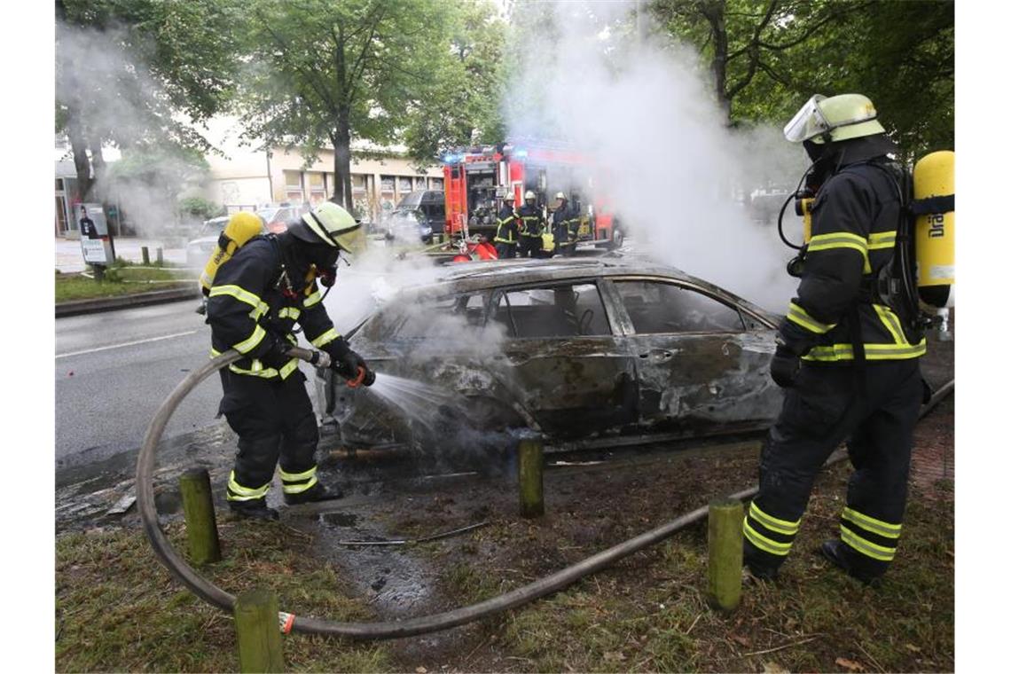 Feuerwehrleute löschen während des G20-Gipfels im Jahr 2017 ein brennendes Auto in Hamburg-Altona. Foto: Bodo Marks/dpa