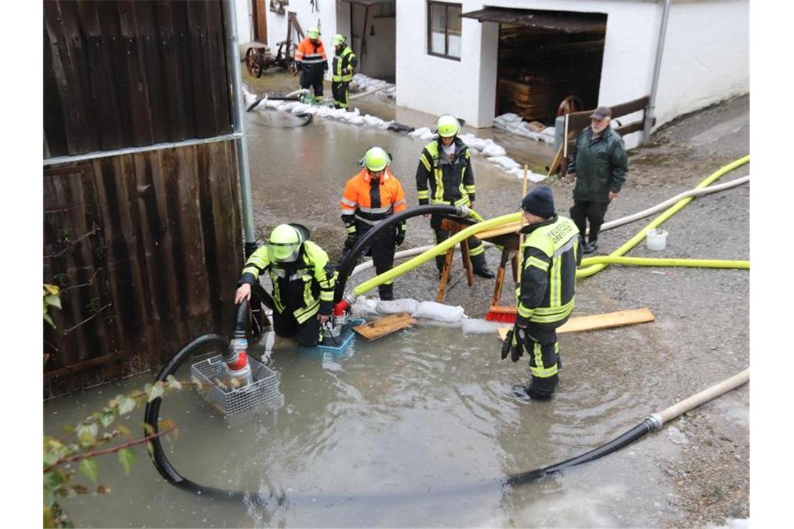Unwetter in Bayern: Zunächst nur kleinere Straßensperrungen Feuerwehrleute pumpen an einem Haus bei Oberstdorf Wasser ab. Foto: Benjamin Liss/dpa