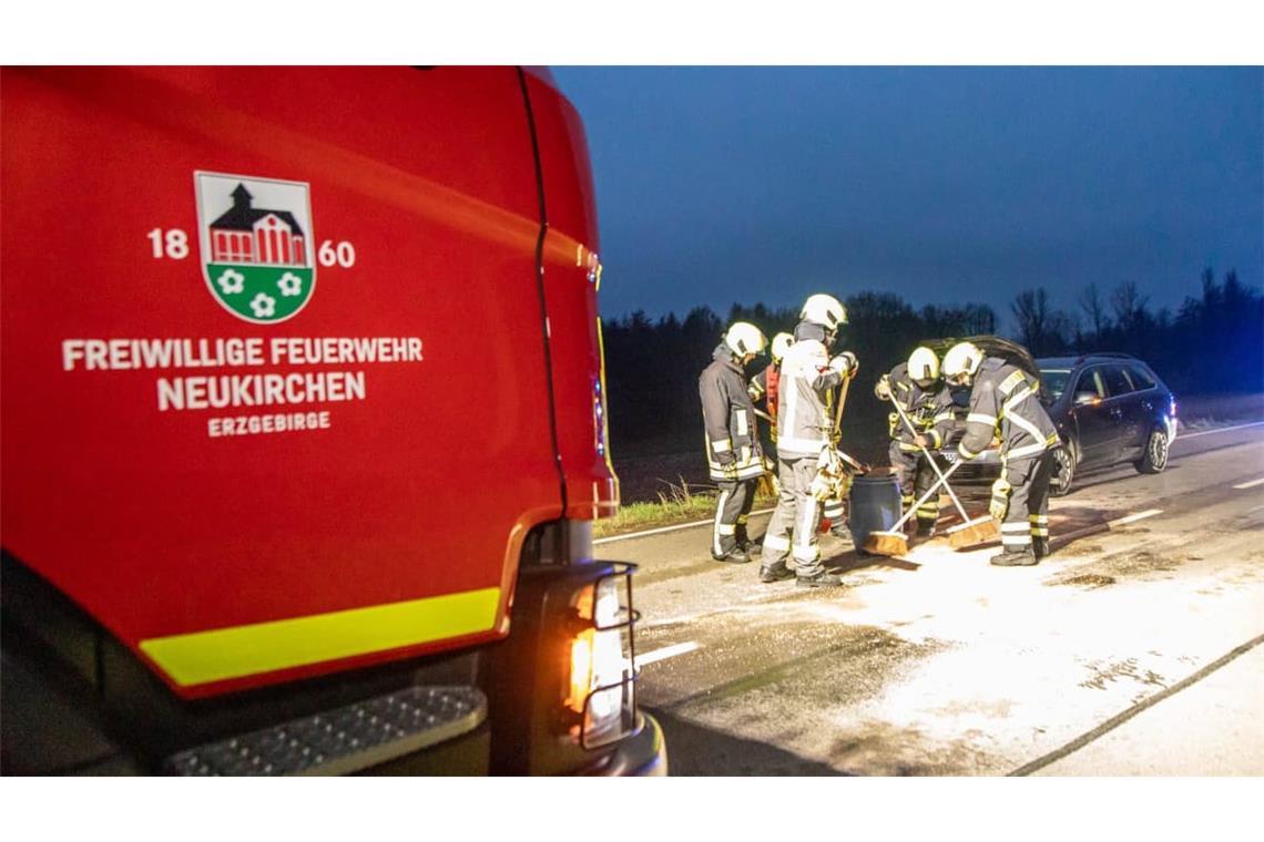 Feuerwehrleute reinigen die Fahrbahn nach einem Wildunfall.