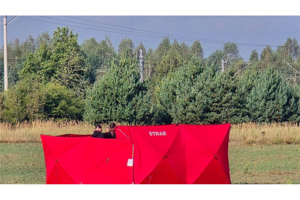 Feuerwehrleute sichern Teile einer abgeschossenen Drohne auf einem Gelände in Czosnowka bei Biala Podlaska.