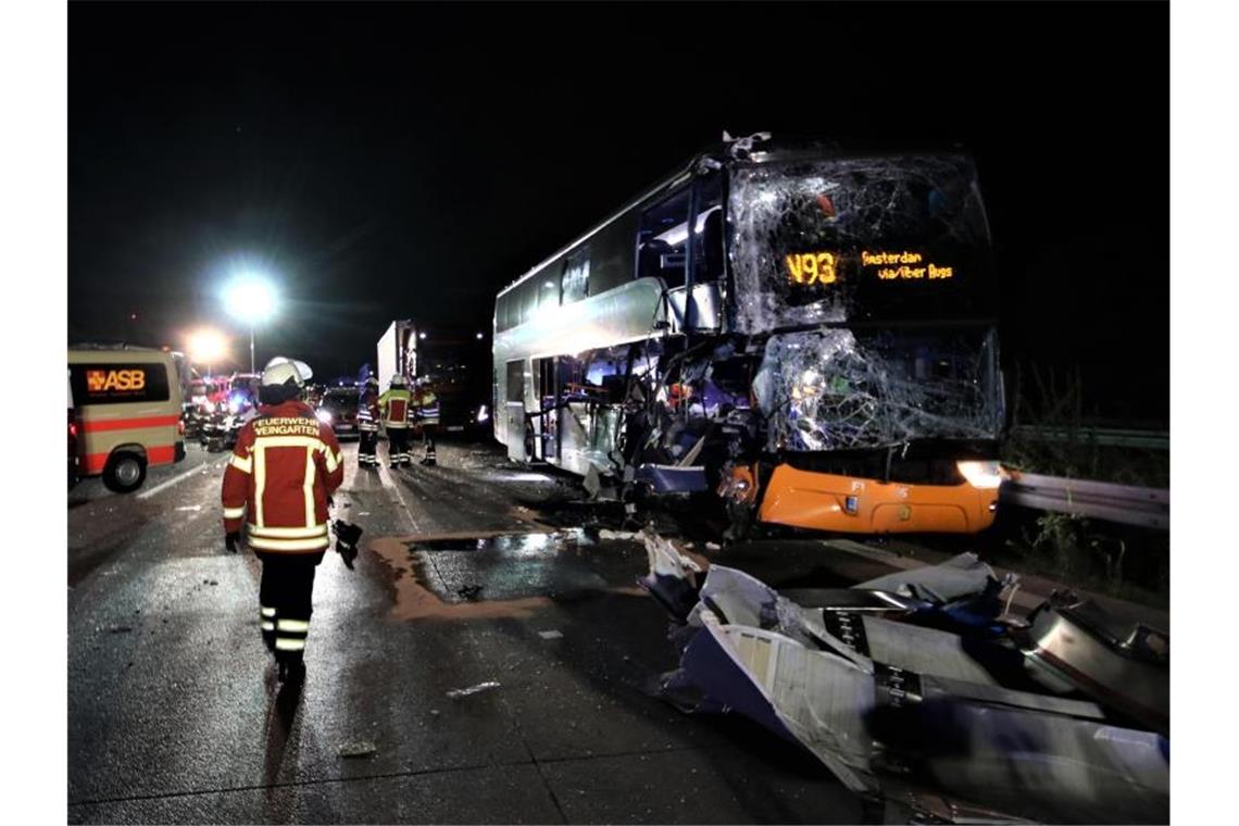 Feuerwehrleute sind nach einem Unfall eines Reisebusses mit einem Lastwagen auf der A5 bei Weingarten im Einsatz. Foto: Thomas Riedel