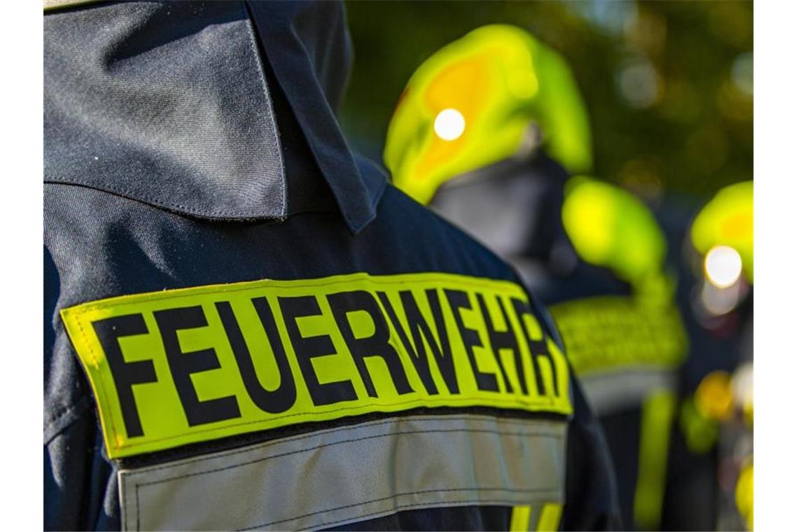 53-Jähriger stirbt bei Wohnhausbrand in Hirschberg Feuerwehrleute stehen am Einsatzort zusammen. Foto: David Inderlied/dpa/Symbolbild
