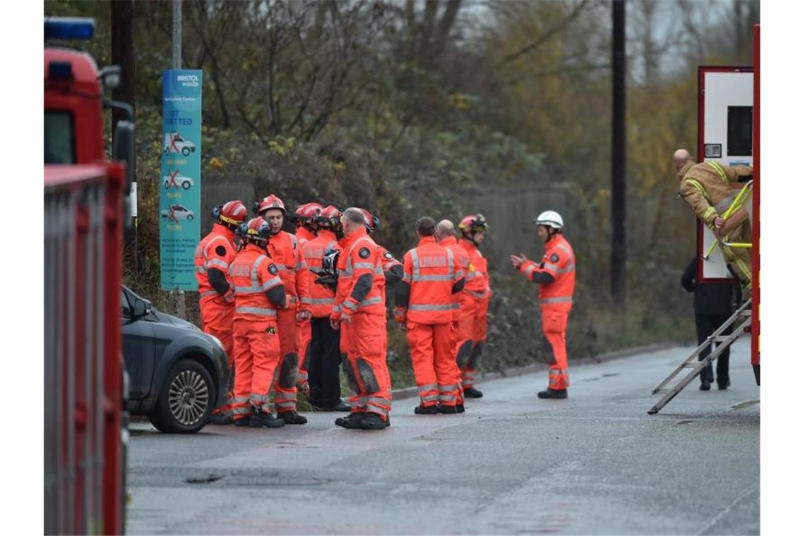 Vier Tote bei Explosion nahe Bristol Feuerwehrleute stehen am Schauplatz nach einer große Explosion in einem Lagerhaus nahe Bristol. Foto: Ben Birchall/PA Wire/dpa