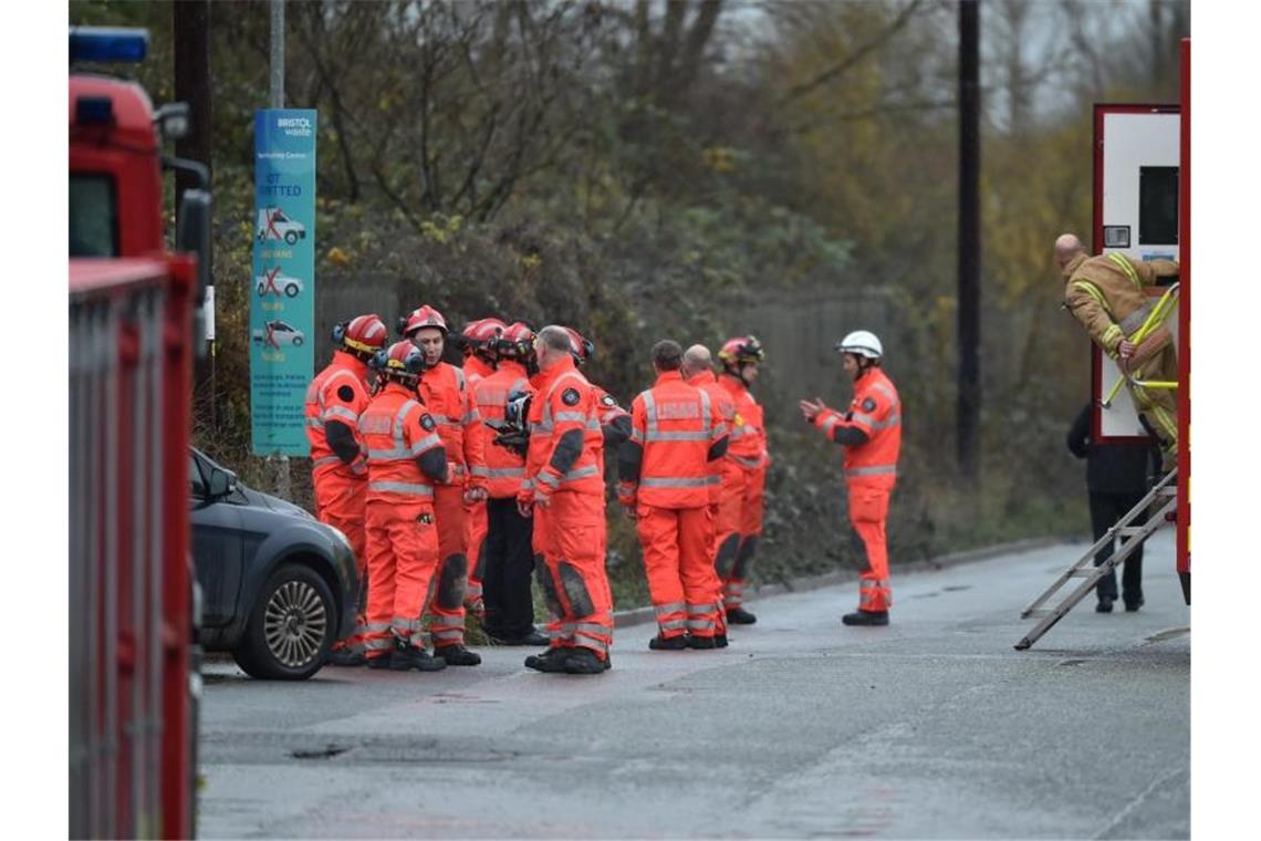 Feuerwehrleute stehen am Schauplatz nach einer große Explosion in einem Lagerhaus nahe Bristol. Foto: Ben Birchall/PA Wire/dpa