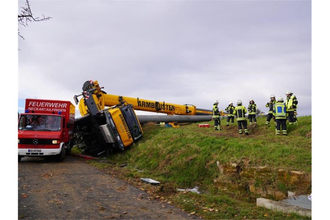 Mann durch umgekippten Kran verletzt Feuerwehrleute stehen an einem umgekippten Kranwagen. Foto: Kohls/SDMG/dpa