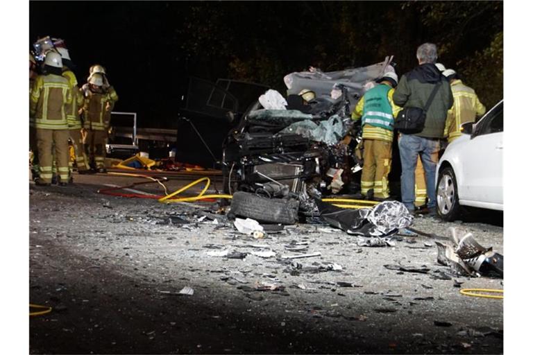 Feuerwehrleute stehen auf der B10 neben einen zerstörten PKW. Foto: Sdmg / Hemmann/dpa