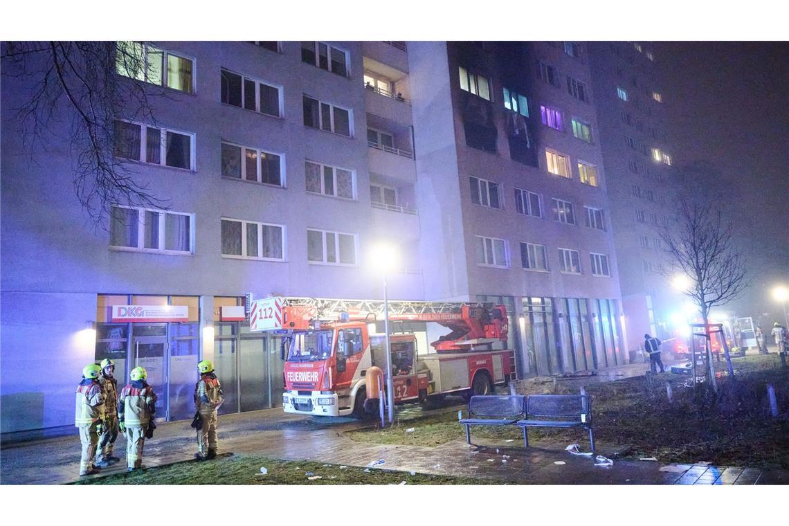 Feuerwehrleute stehen für Löscharbeiten vor einem Wohnhaus. (Archivbild)