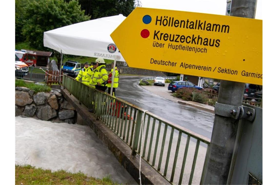 Weiter Vermisste nach Flutwelle in den Alpen Feuerwehrleute stehen in Grainau nach einer Flutwelle in der Höllentalklamm bereit, um Opfer aus dem Fluss Hammersbach zu bergen. Foto: Peter Kneffel/dpa