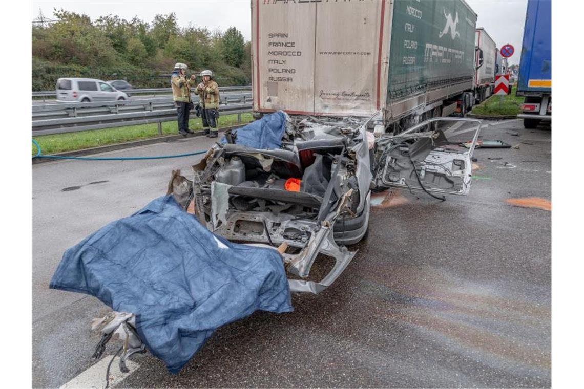 Feuerwehrleute stehen neben einem Autowrack an einer Unfallstelle auf der Autobahn 5. Foto: -/Einsatz-Report24 /dpa