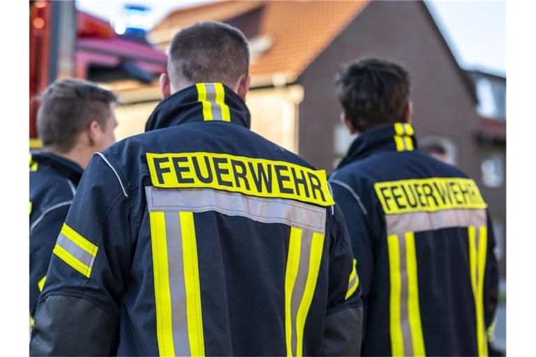 Feuerwehrleute stehen zusammen, um den Einsatz zu besprechen. Foto: David Inderlied/dpa/Symbolbild