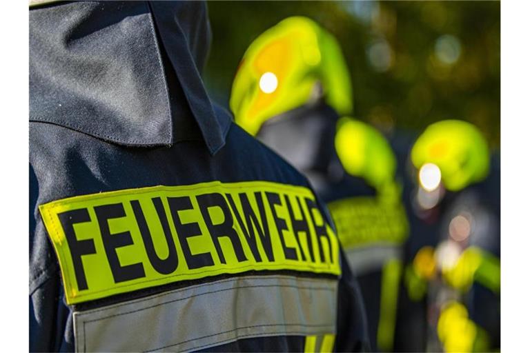 Feuerwehrleute stehen zusammen, um den Einsatz zu besprechen. Foto: David Inderlied/dpa/Symbolbild