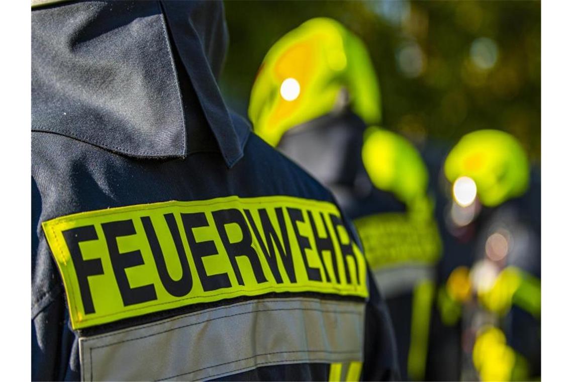 81-Jähriger stirbt nach Brand in Freiburg Feuerwehrleute stehen zusammen, um den Einsatz zu besprechen. Foto: David Inderlied/dpa/Symbolbild