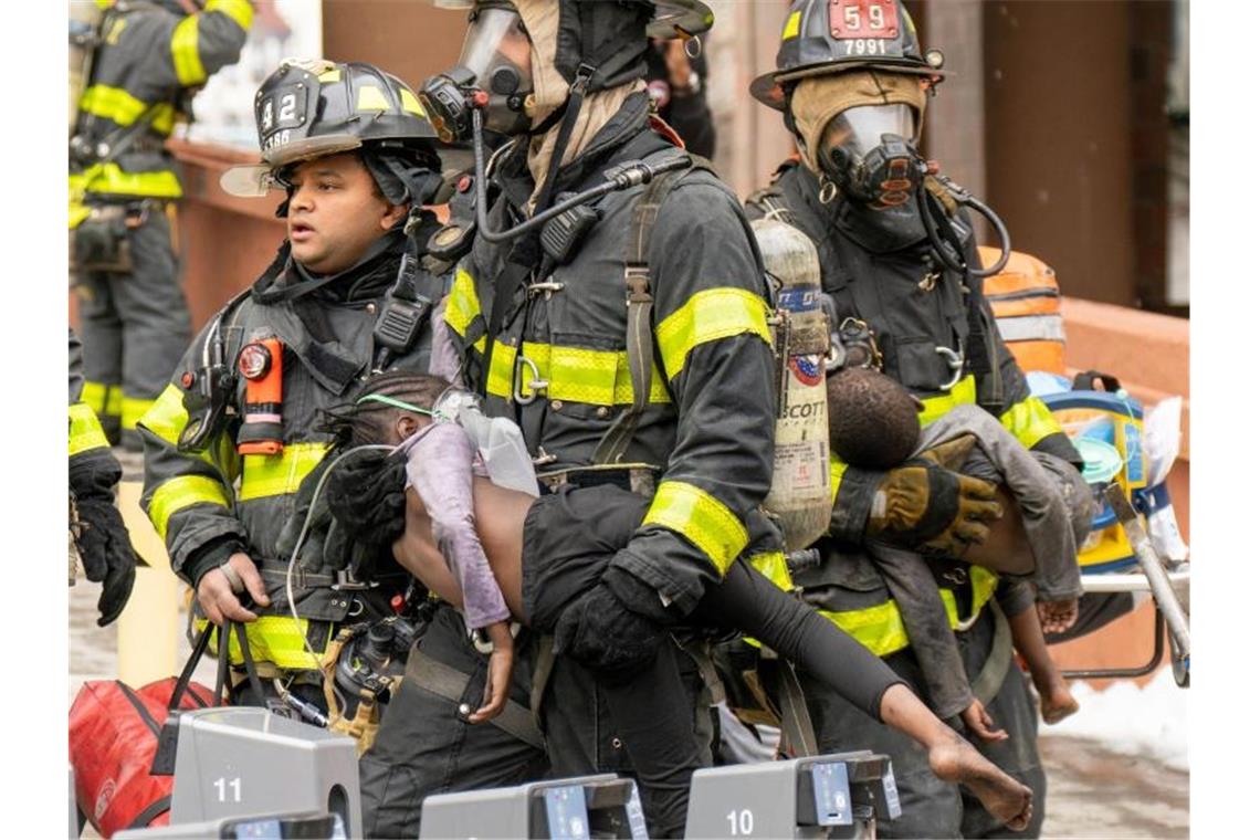 Trauer in New York nach schwerem Wohnhausbrand Feuerwehrleute tragen Kinder aus einem Wohnhaus in der Bronx. Bei dem Feuer sind nach Angaben des Bürgermeisters Adams 17 Menschen getötet worden. Foto: Theodore Parisienne/New York Daily News/TNS via ZUMA Press Wire/dpa