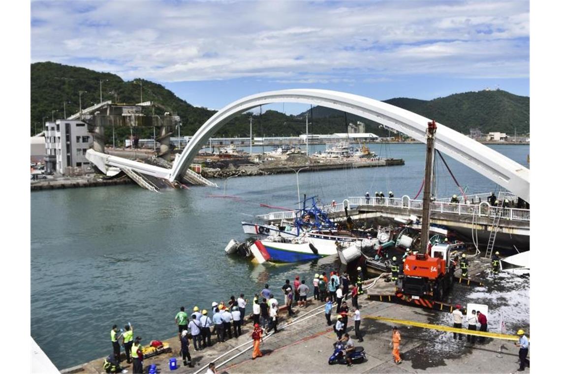 Feuerwehrleute und Rettungskräfte am Unfallort bei Nanfangao in Taiwan nach dem Einsturz einer Brücke. Foto: -/AP/dpa