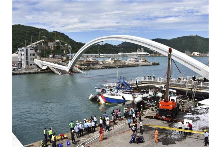 Feuerwehrleute und Rettungskräfte am Unfallort bei Nanfangao in Taiwan nach dem Einsturz einer Brücke. Foto: -/AP/dpa