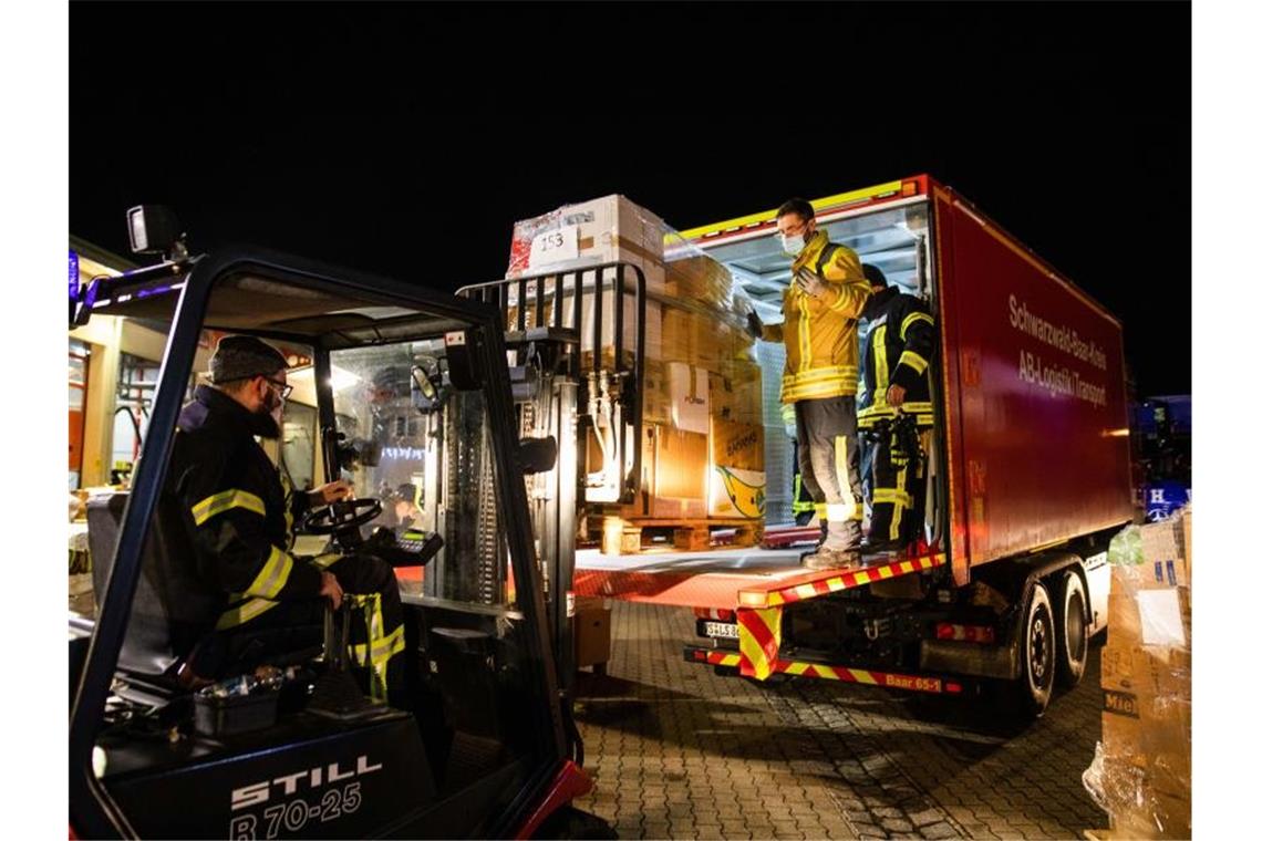 Feuerwehrleute verladen in Bad Krozingen eine Palette mit Hilfsgütern auf einen LKW. Foto: Philipp von Ditfurth/dpa