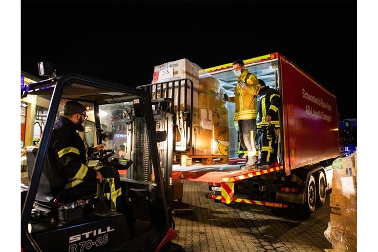 Feuerwehrleute verladen in Bad Krozingen eine Palette mit Hilfsgütern auf einen LKW. Foto: Philipp von Ditfurth/dpa