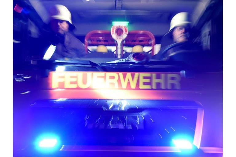 Feuerwehrmänner in einem Löschfahrzeug. Foto: Carsten Rehder/dpa/Archivbild