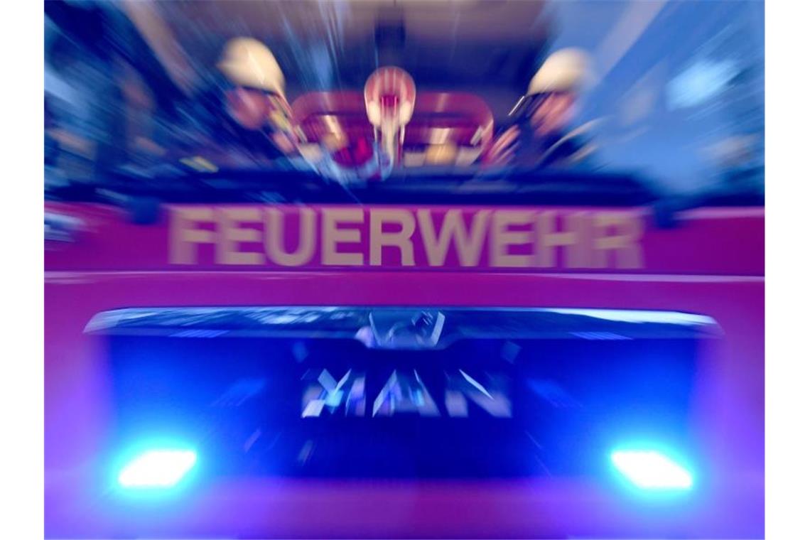 Hoher Sachschaden bei Wohnungsbrand Feuerwehrmänner sind mit Blaulicht im Einsatz. Foto: Carsten Rehder/dpa/Symbolbild