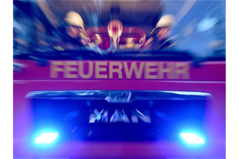 Feuerwehrmänner sind mit Blaulicht im Einsatz. Foto: Carsten Rehder/dpa/Symbolbild