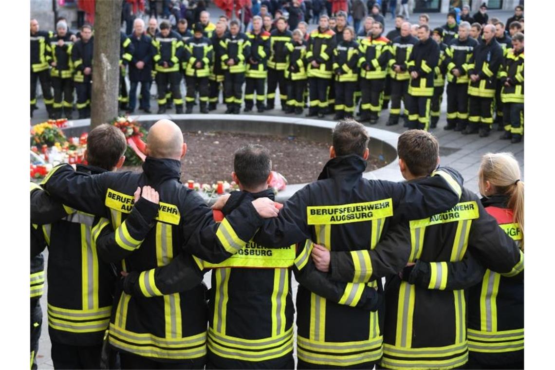 Passant in Augsburg auf offener Straße getötet Feuerwehrmänner trauern in Augsburg um ihren toten Kollegen. Foto: Stefan Puchner/dpa