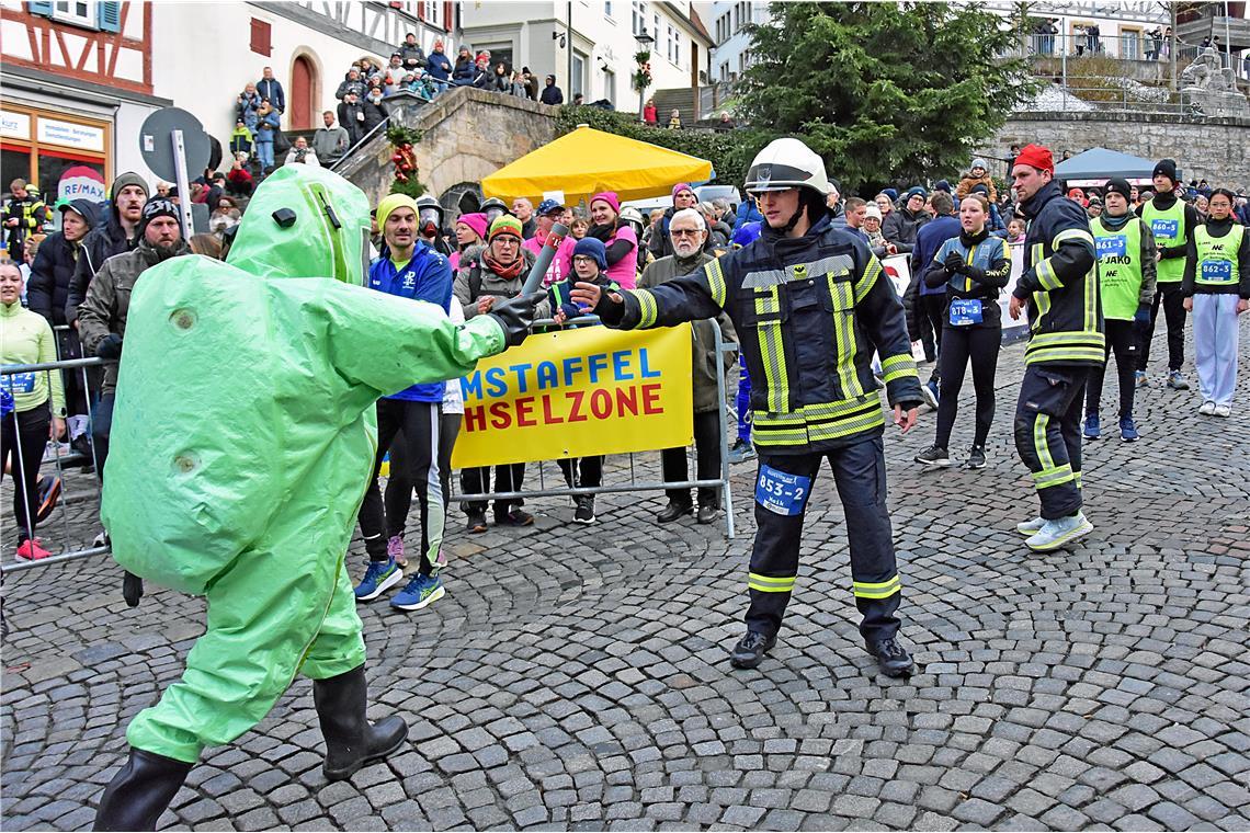 Feuerwehrmann Niels übergibt in seiner Schutzausrüstung seinem Kameraden Maik de...