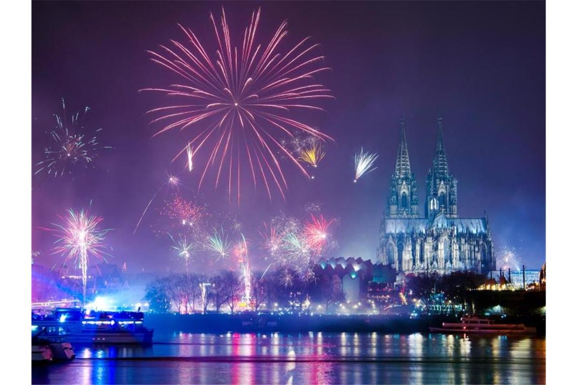 Feuerwerk ist in der Silvesternacht am Rhein über dem Dom zu sehen. Foto: Christophe Gateau/dpa