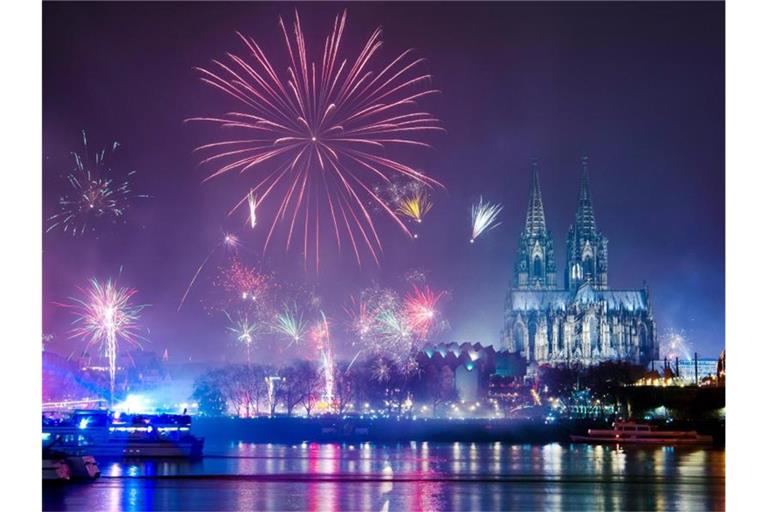 Feuerwerk ist in der Silvesternacht am Rhein über dem Dom zu sehen. Foto: Christophe Gateau/dpa