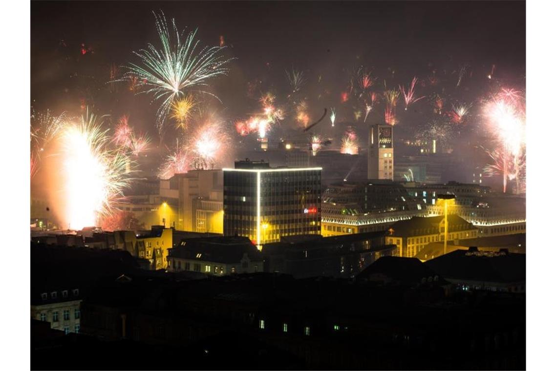 Feuerwerk wird in den nächtlichen Himmel über der Stadt abgefeuert. Foto: Christoph Schmidt/dpa