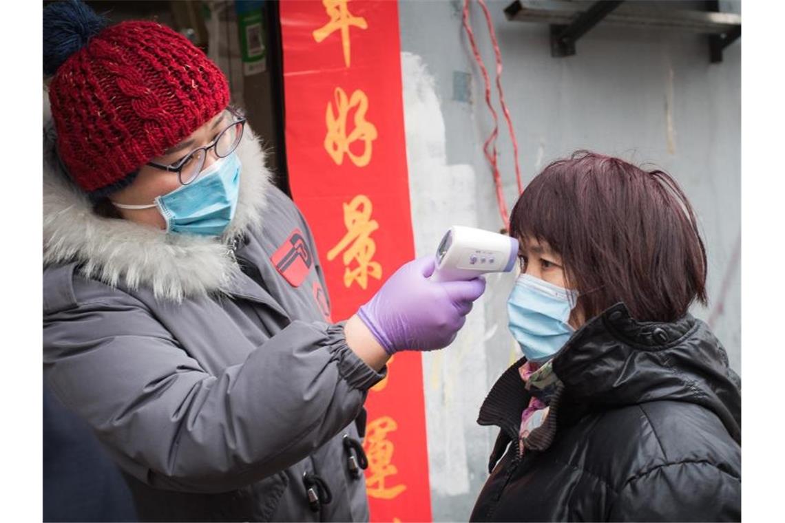 Fiebermessung bei einer Passantin in Wuhan. Foto: Xiao Yijiu/XinHua/dpa