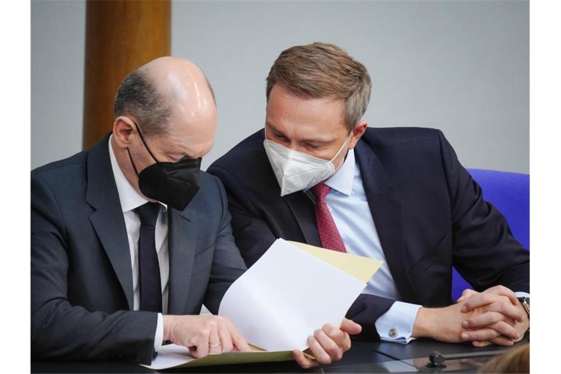 Ein „Haushaltsrätsel“: Lindner bringt Etat für 2022 ein Finanzminister Christian Lindner (r, FDP) und Bundeskanzler Olaf Scholz (SPD) unterhalten sich im Bundestag. Foto: Kay Nietfeld/dpa