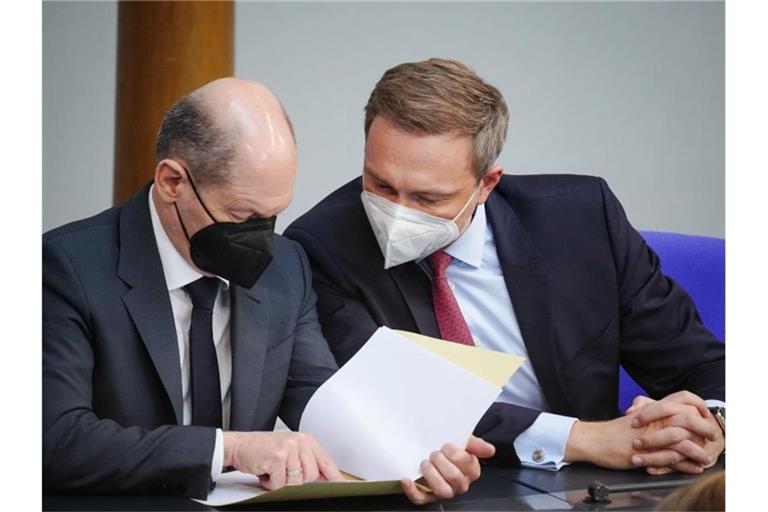 Finanzminister Christian Lindner (r, FDP) und Bundeskanzler Olaf Scholz (SPD) unterhalten sich im Bundestag. Foto: Kay Nietfeld/dpa