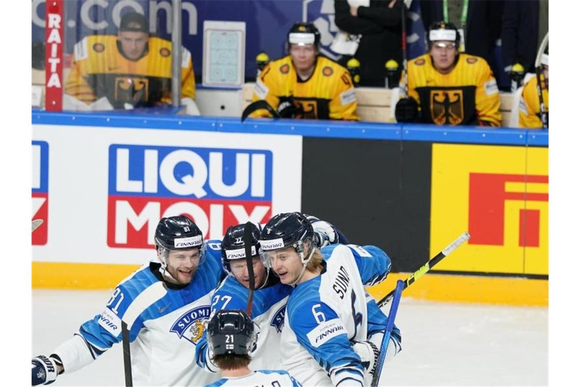 DEB-Team gerät nach Niederlage gegen Finnen unter Druck Finnlands Spieler jubeln nach einem Treffer - im Hintergrund die deutsche Bank. Foto: Roman Koksarov/dpa