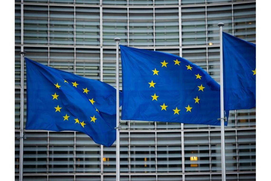 Schnelle Erholung der EU-Wirtschaft - aber mögliche Hürden Flaggen der Europäischen Union wehen im Wind vor dem Berlaymont-Gebäude der Europäischen Kommission in Brüssel. Foto: Arne Immanuel Bänsch/dpa