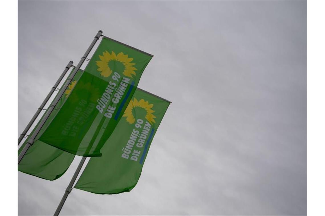 Flaggen mit dem Logo von Bündnis 90/Die Grünen wehen vor einem Veranstaltungszentrum. Foto: Marijan Murat/dpa/Archivbild