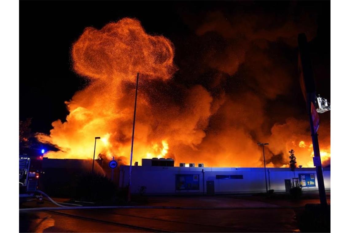Supermarkt brennt komplett ab: Millionenschaden Flammen schlagen aus einem Lebensmittelmarkt. Foto: Kohls/SDMG/dpa