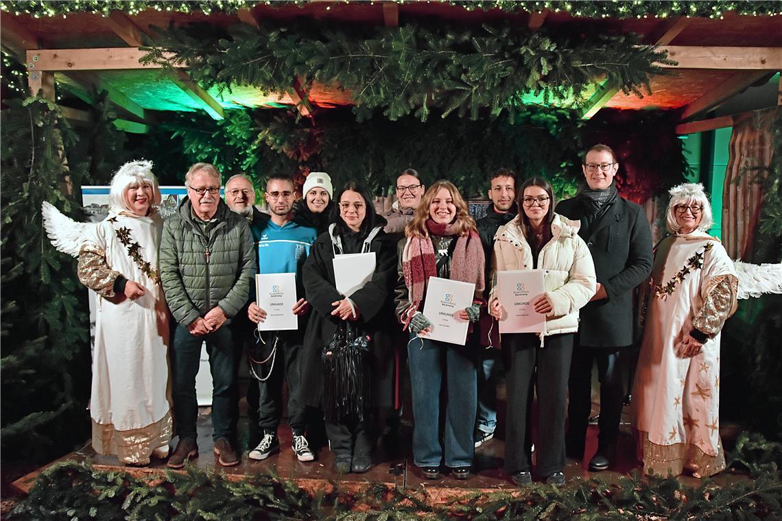 Flankiert von zwei Weihnachtsengeln ehren Klaus Böhle und Ulrich Schielke (von links) von der Bürgerstiftung zusammen mit OB Maximilian Friedrich (rechts) junge Ehrenamtliche für ihr Engagement: (von links) Marco Ottenbacher, Selina Häußer (stellvertretend für Manuel Stroh Prieto), Liliane Dambacher, Julia Schwager, Julia Schröder, Axel Koblinger und Emilia Petkovski. Foto: Tobias Sellmaier
