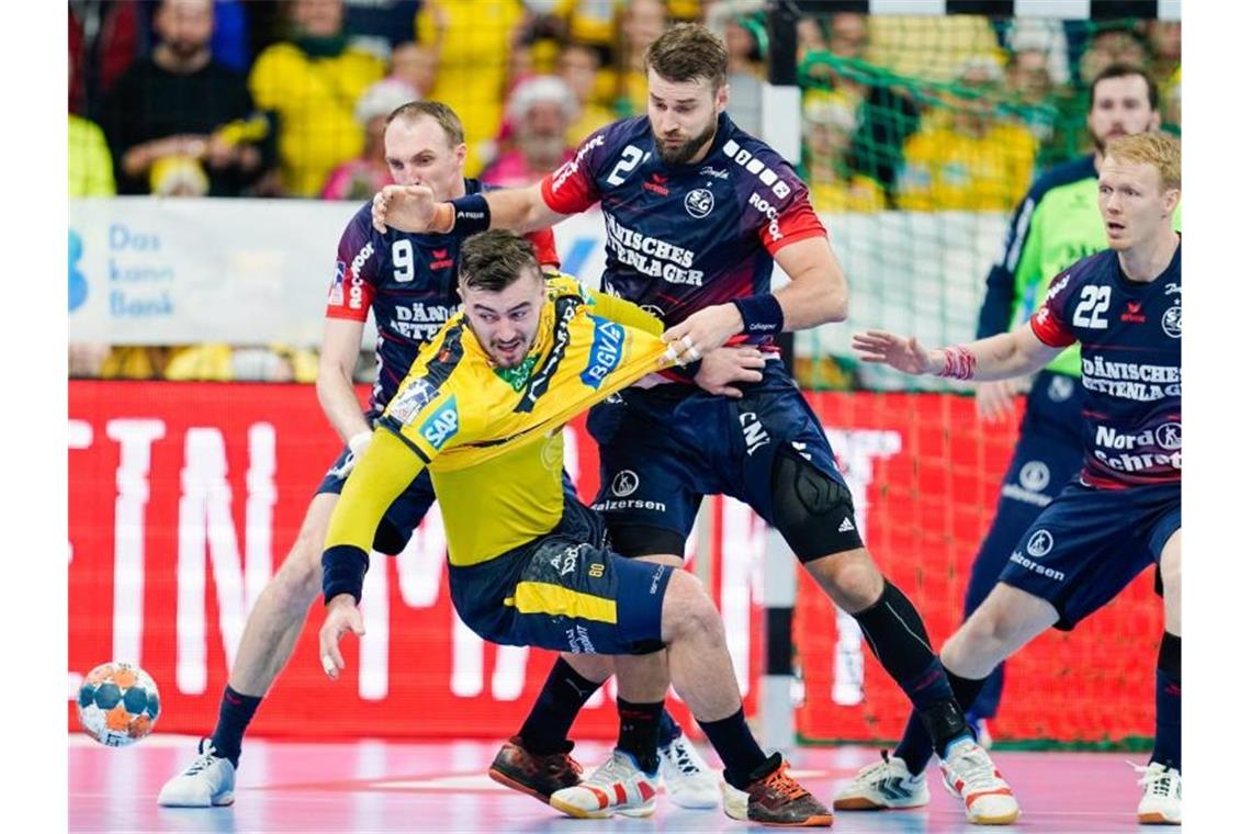 Flensburgs Holger Glandorf (l-r), Jannik Kohlbacher von den Rhein-Neckar Löwen und Flensburgs Jim Gottfridsson kämpfen um den Ball. Foto: Uwe Anspach/dpa
