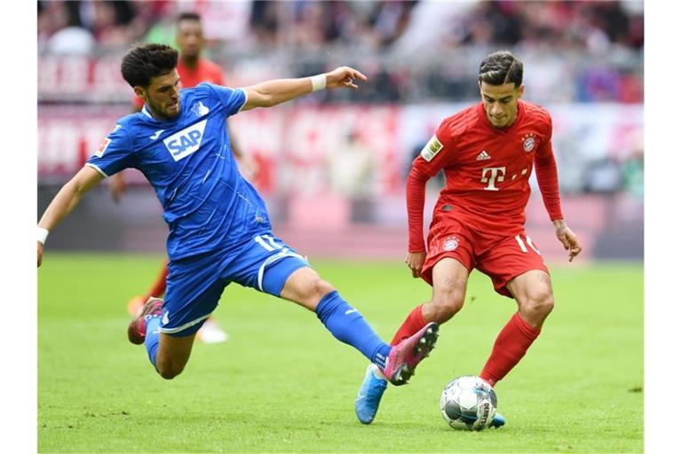 Florian Grillitsch (l.) von Hoffenheim und Philippe Coutinho von Bayern kämpfen um den Ball. Foto: Tobias Hase/dpa