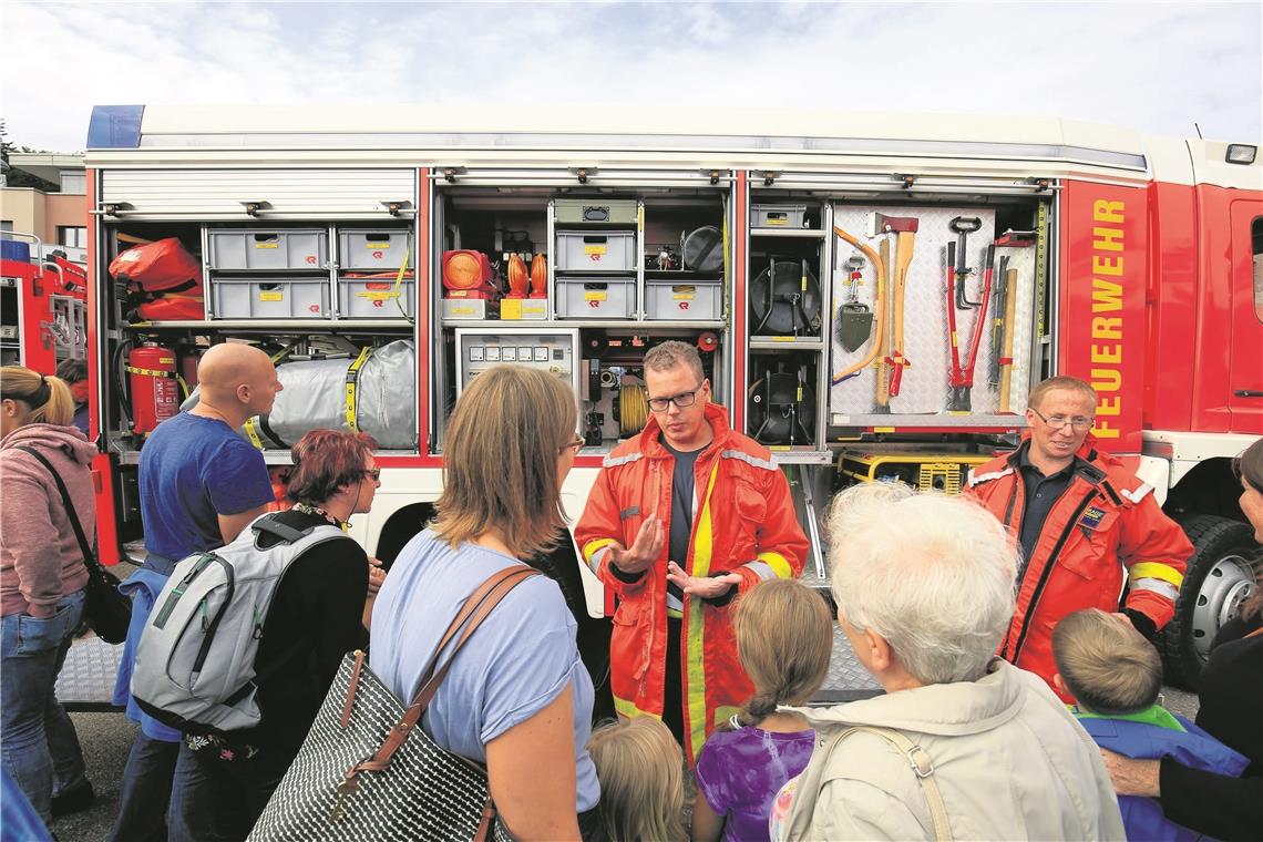 Florian Korfmann (Mitte) und Daniel Siegel (rechts) erklären die Aufgaben der Feuerwehr.